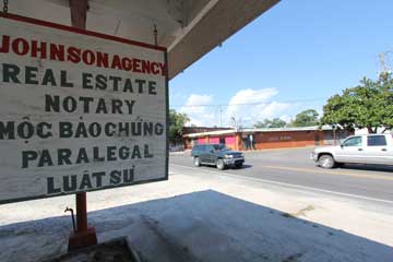 On Wintzell Avenue, a notary public advertises in multiple languages across the street from an Asian grocer and a shuttered Vietnamese pool hall. Bayou la Batre, Alabama, August 31, 2015. (VOA Photo/Victoria Macchi)