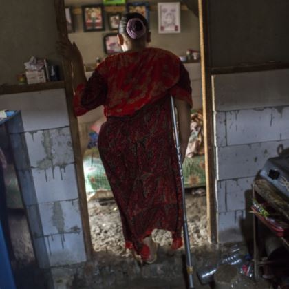 Photo of Rasminah standing in a doorway between the kitchen and the bedroom.