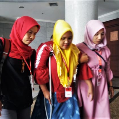 Rasminah, center, along with two other child marriage victims, leaves a hearing.