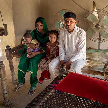 Photo of Qubra sitting with her husband, Dodo Khan, and their son and daughter.