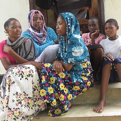 Photo of Mwahanamisi Abdallah, center, sitting on steps with four other girls.