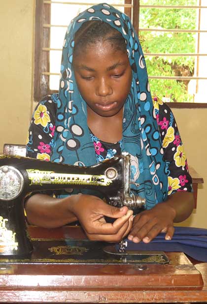 Photo of Mwahanamisi Abdallah using a sewing machine.
