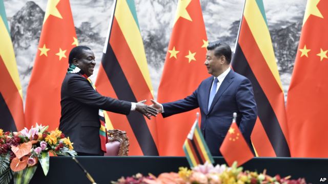 Zimbabwean President Emmerson Mnangagwa, left, shakes hands with Chinese President Xi Jinping as they pose for the media after a signing ceremony at the Great Hall of the People in Beijing, China, April 3, 2018. 