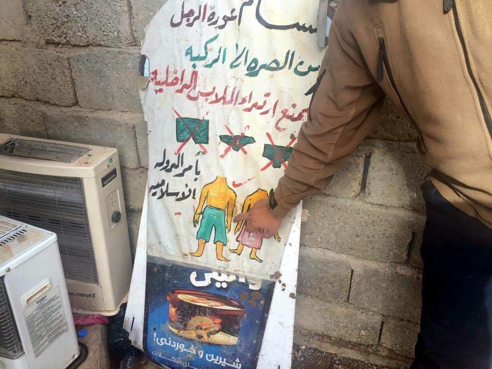 Pasted over an ice-cream advertisement in a village in Nineveh province west of Mosul are IS instructions as to which kind of underwear is permitted and which is prohibited. (H. Murdock\/VOA) Dec. 16, 2016.
