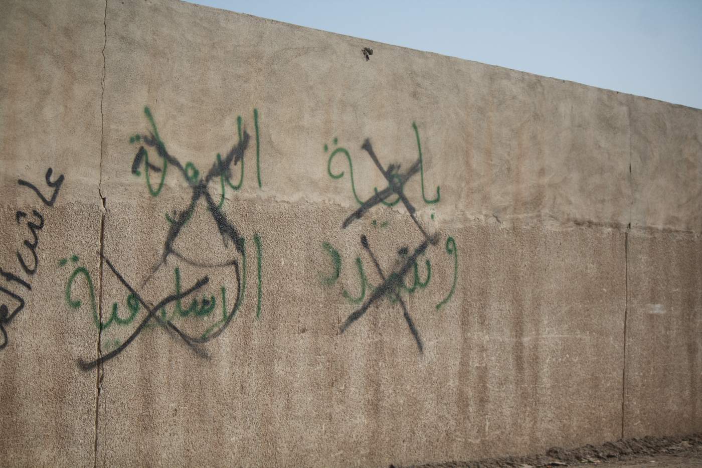 Graffiti in Mosul, Iraq, proclaimed &quot;Islamic State remains&quot; before it was crossed out as Iraqi forces took back the neighborhood on Jan. 11, 2017. (H. Murdock\/VOA)