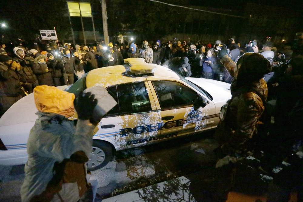 Rioters damage a Ferguson police car: Photo AP