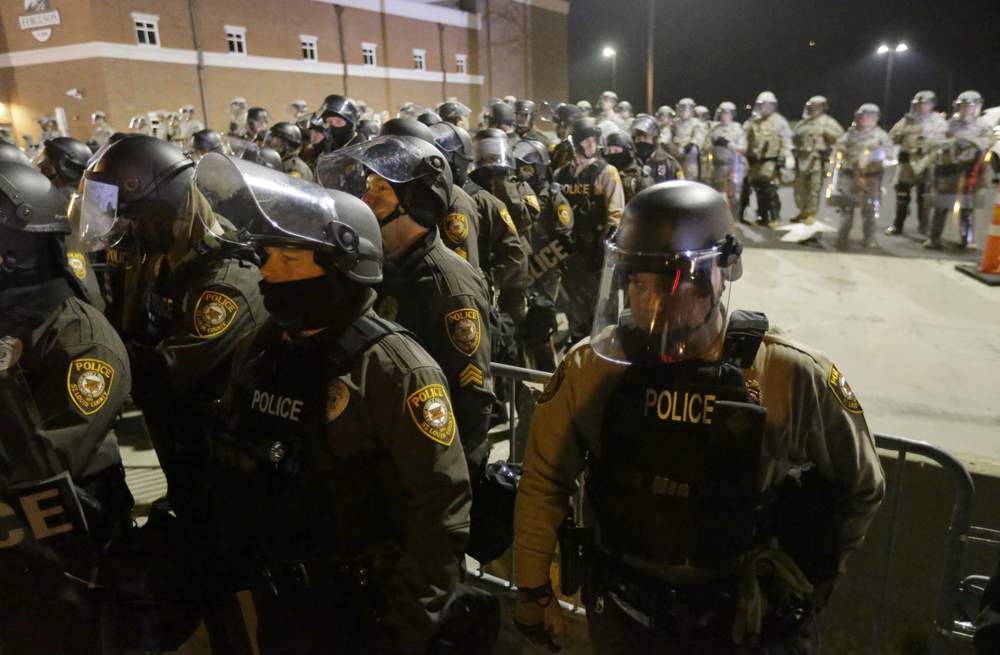 Police officers protect the Ferguson police station: Photo AP