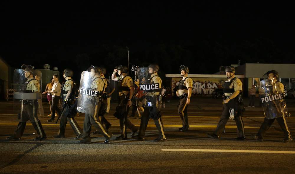 Police walk along West Florissant Ave in Ferguson: Photos AP