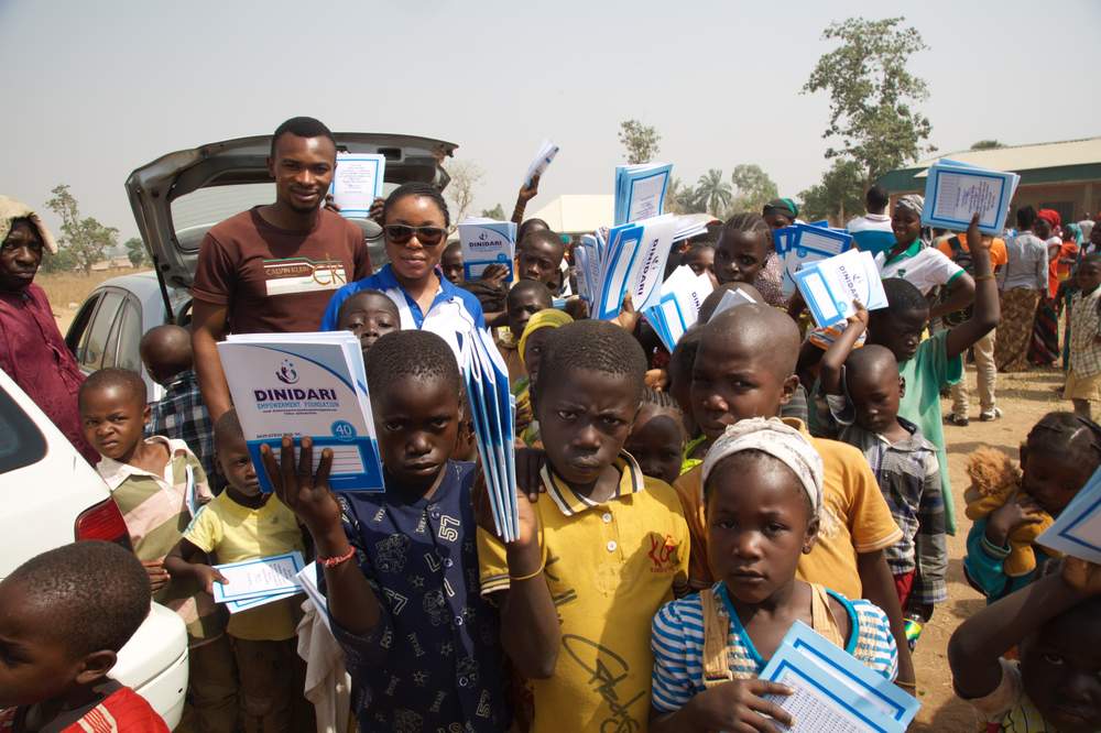 Ndi Kato, an activist from southern Kaduna, meets with children in a relief camp to distribute free notebooks. 