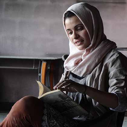 Tahany Saleh reads through a book rescued from the rubble of Mosul University’s Central Library in Mosul, Iraq. 