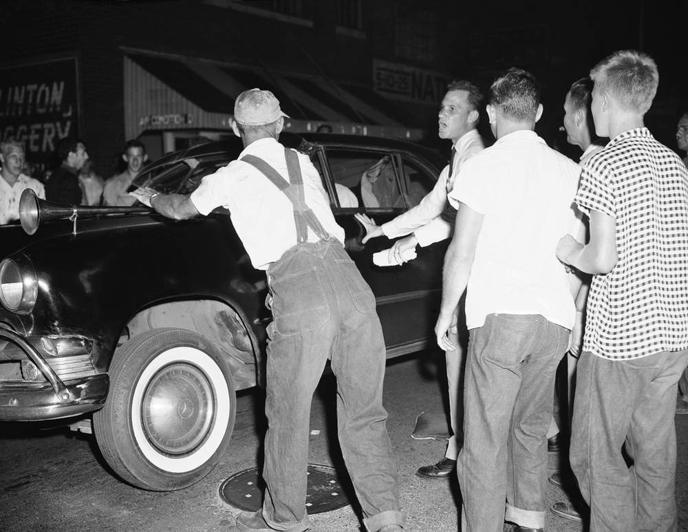 An unidentified newsman tries to stop an angry white mob from rocking a car of black passengers in Clinton, Tennessee, on Sept. 1, 1956. The mob was fired up by a pro-segregation speech by Asa Carter of Birmingham, Ala. (AP Photo\/Gene Herrick)